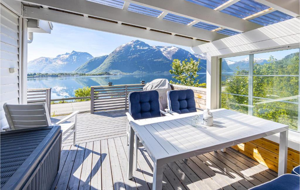2 Bedroom Awesome Home In Isfjorden في Isfjorden: فناء مع طاولة وكراسي وإطلالة على الماء