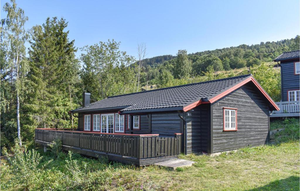 a log cabin with a deck in the woods at Amazing Home In yer With Kitchen in Øyer