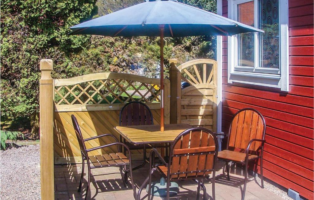 a table and chairs with an umbrella on a patio at Stunning Home In ngelholm With 1 Bedrooms in Ängelholm