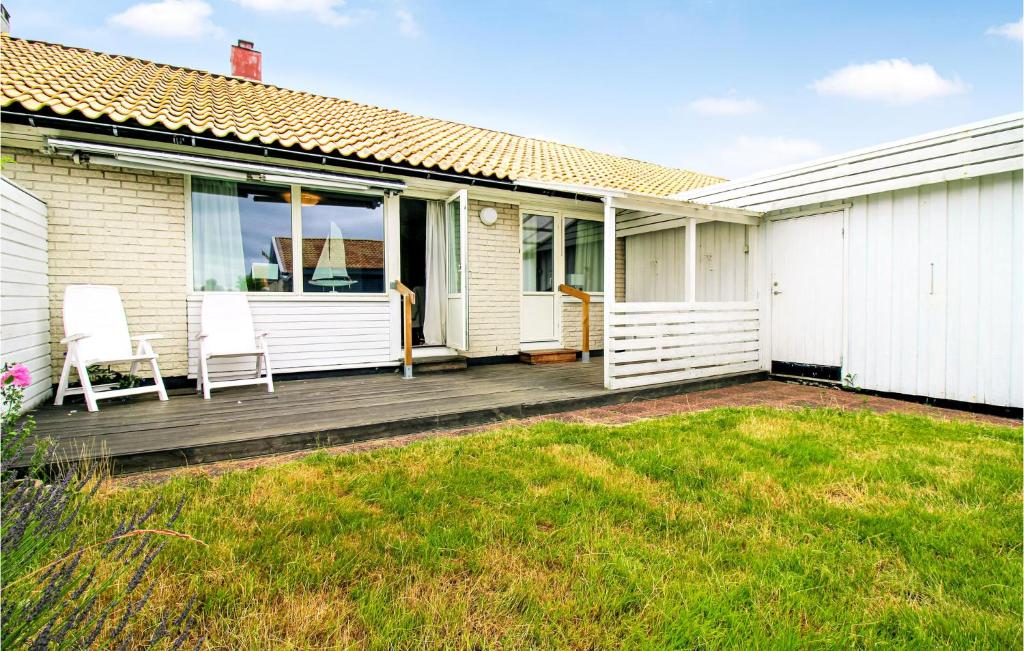 a house with a wooden deck with two chairs on it at 1 Bedroom Stunning Home In Viken in Viken