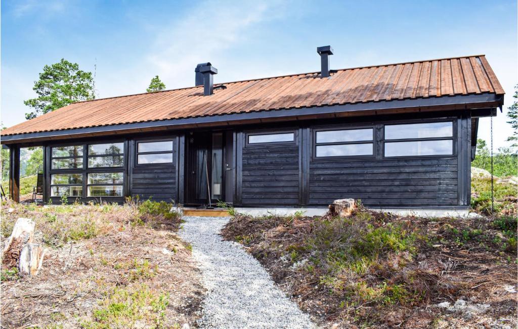 una casa de madera con un techo oxidado en un campo en Beautiful Home In Fl With Kitchen en Flå