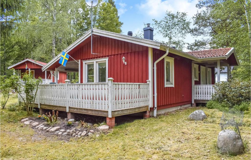 ein rotes winziges Haus mit einem weißen Zaun in der Unterkunft 2 Bedroom Beautiful Home In Vstra Torup in Västra Torup