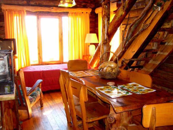 a room with a table and a bed in a cabin at Cabañas El Milagro in San Roque