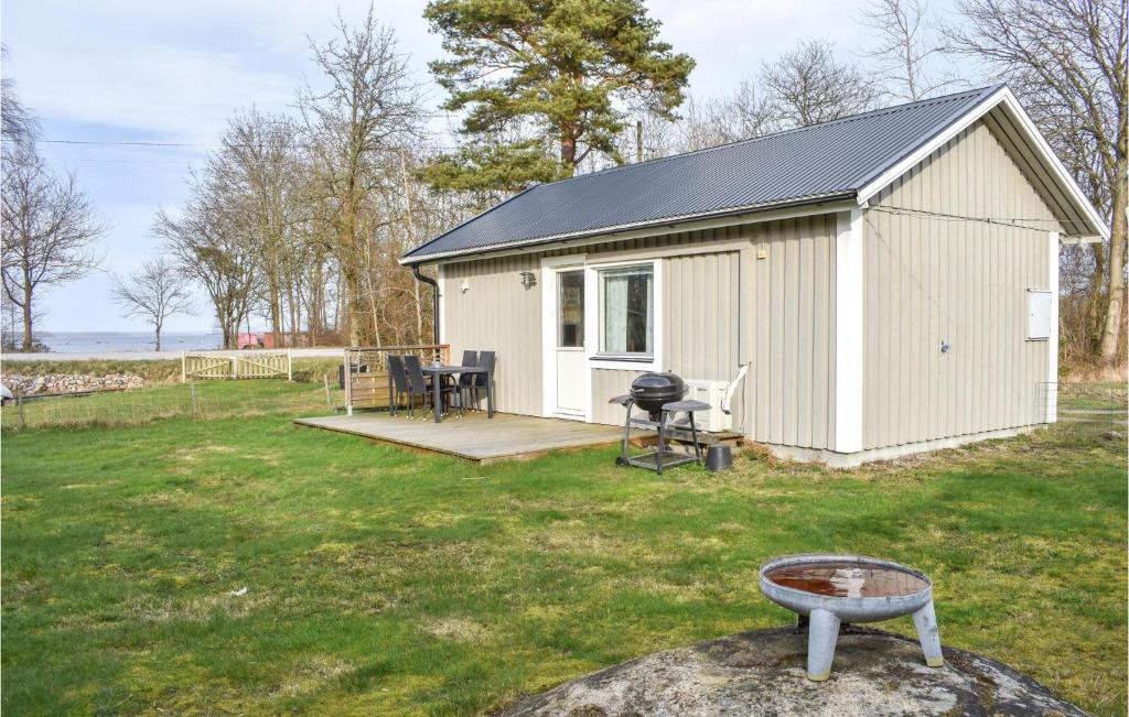 a white shed with a grill in a yard at Pet Friendly Home In Hassl With Kitchen in Hasslö
