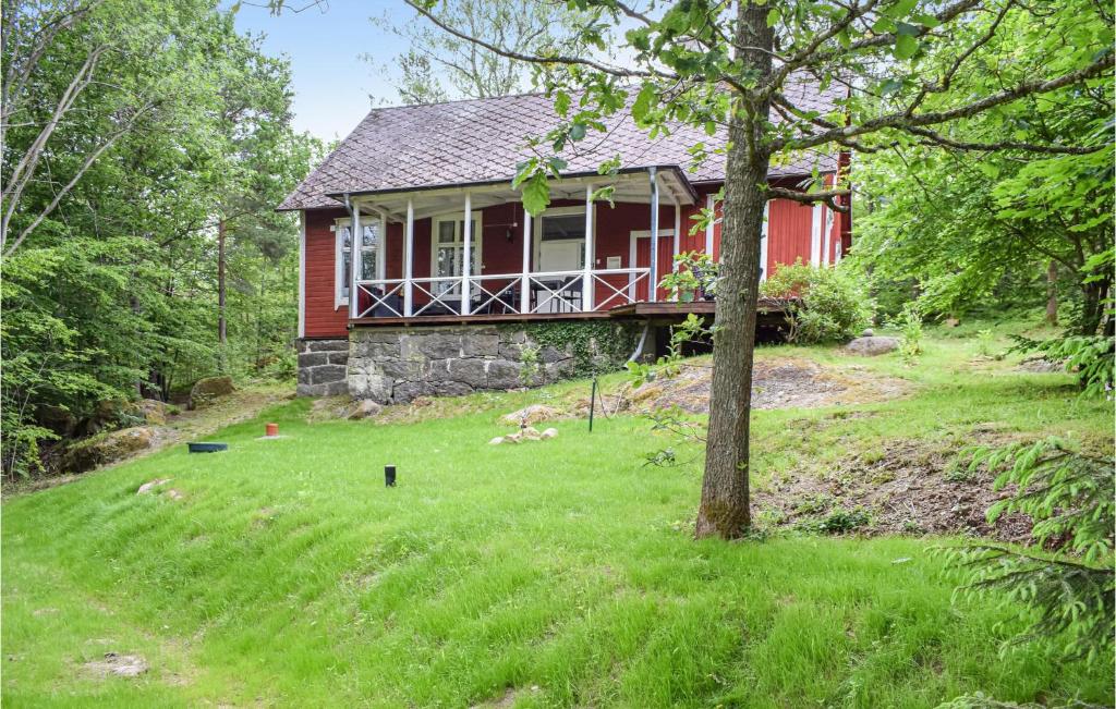 a red house in the middle of a grassy yard at Cozy Home In Asarum With Wifi in Asarum