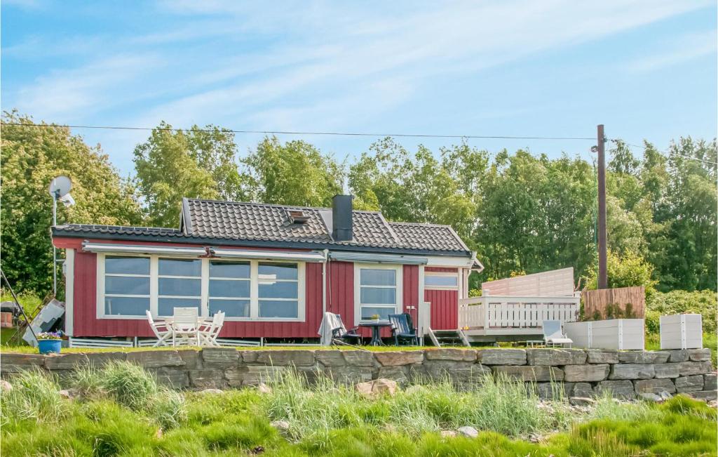 a red tiny house with a stone wall at Nice Home In Malvik With Kitchen in Malvik