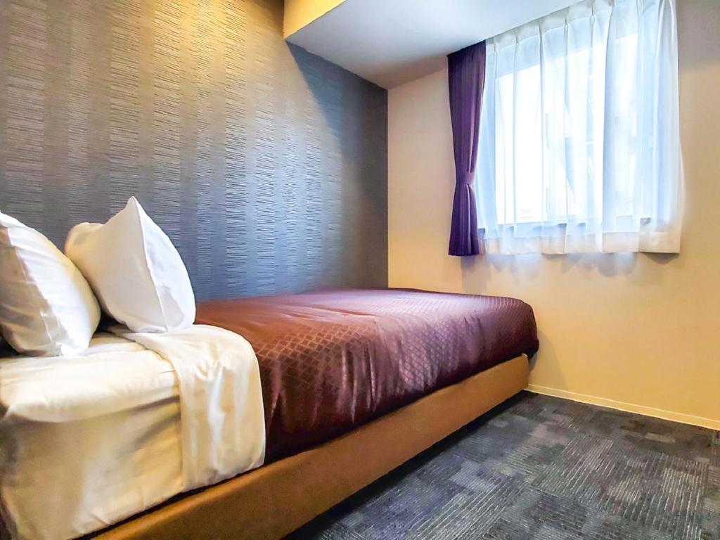 Postel nebo postele na pokoji v ubytování HOTEL LiVEMAX Tachikawa Ekimae