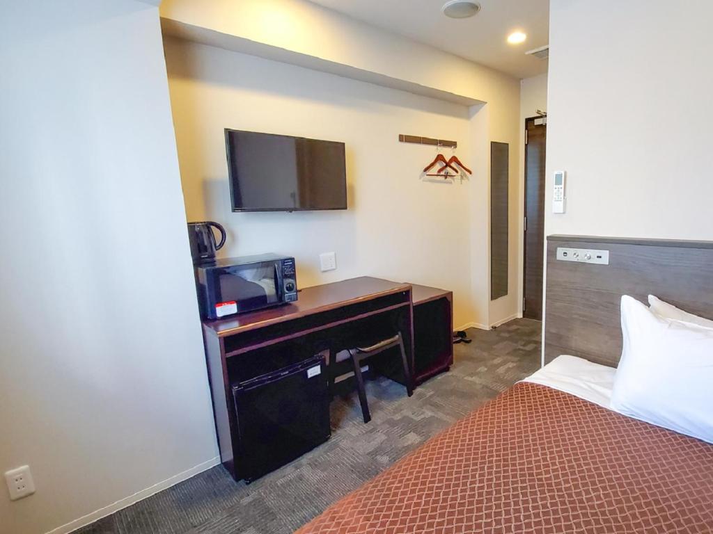 Postel nebo postele na pokoji v ubytování HOTEL LiVEMAX Tachikawa Ekimae