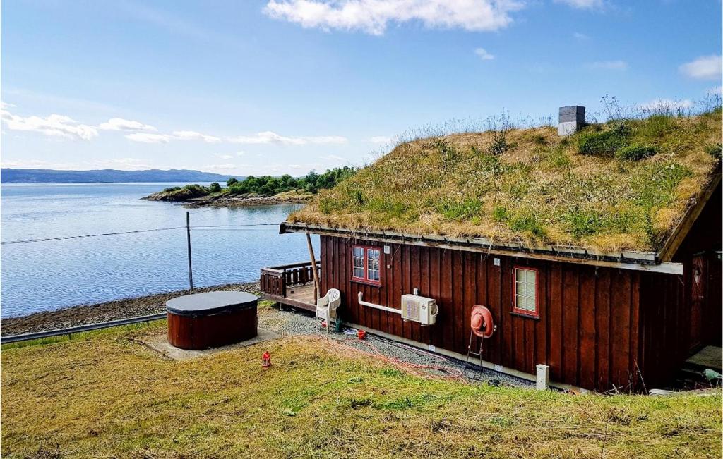 una casa con techo de hierba con agua en Nice Home In Malm With Lake View, 
