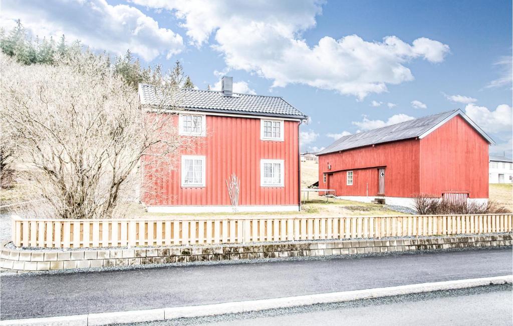 a red house with a fence next to a red barn at 3 Bedroom Cozy Home In Levanger in Levanger
