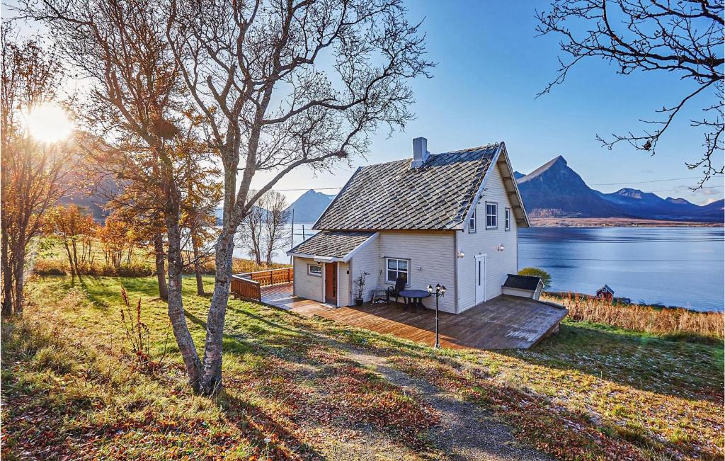 Lovely Home In Sortland With Wifi في سورتلاند: بيت أبيض صغير على شاطئ البحيرة