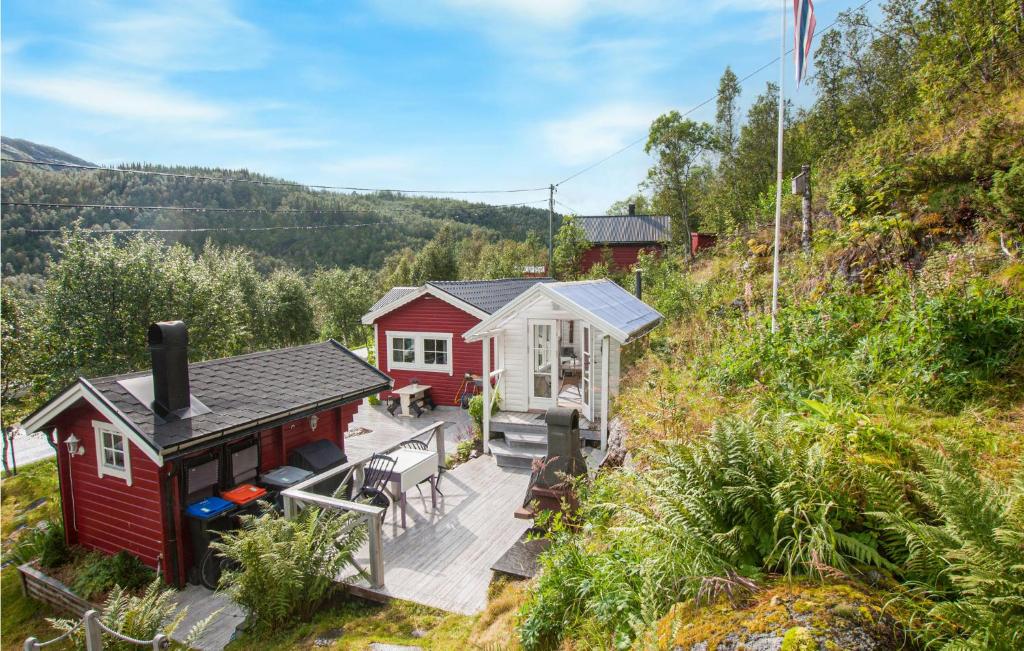 una pequeña casa roja con terraza en una colina en Nice Home In Bjerkvik With Wifi en Bjerkvik
