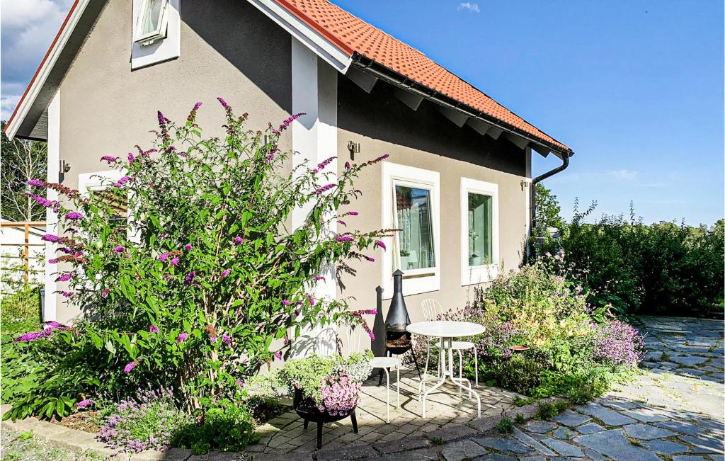 une petite maison avec une table, des chaises et des fleurs dans l'établissement Stunning Home In Oskarshamn With Wifi, à Oskarshamn