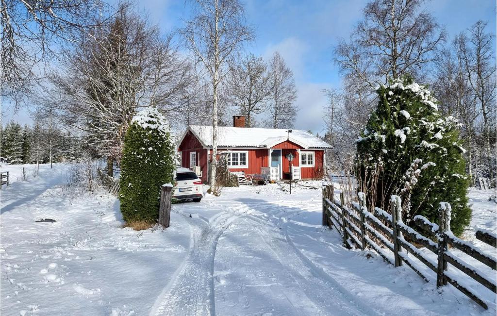 een rood huis met een hek in de sneeuw bij Amazing Home In Mullsj With 2 Bedrooms in Mullsjö