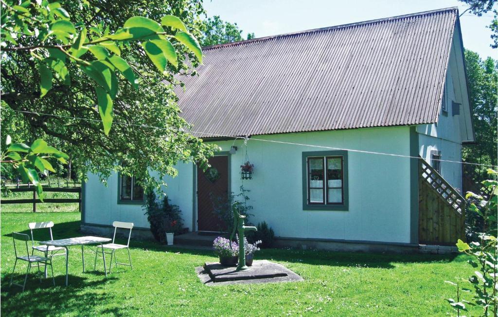 a small blue house with chairs in the yard at Awesome Home In Visby With Kitchenette in Vall