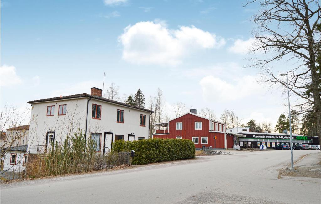 a street with a white house and a red building at 2 Bedroom Stunning Apartment In Hlleforsns in Hälleforsnäs