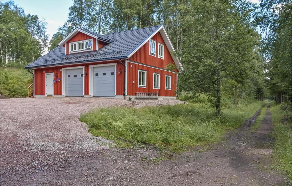 un fienile rosso con due porte garage su un lotto di 2 Bedroom Cozy Apartment In Årjäng a Årjäng