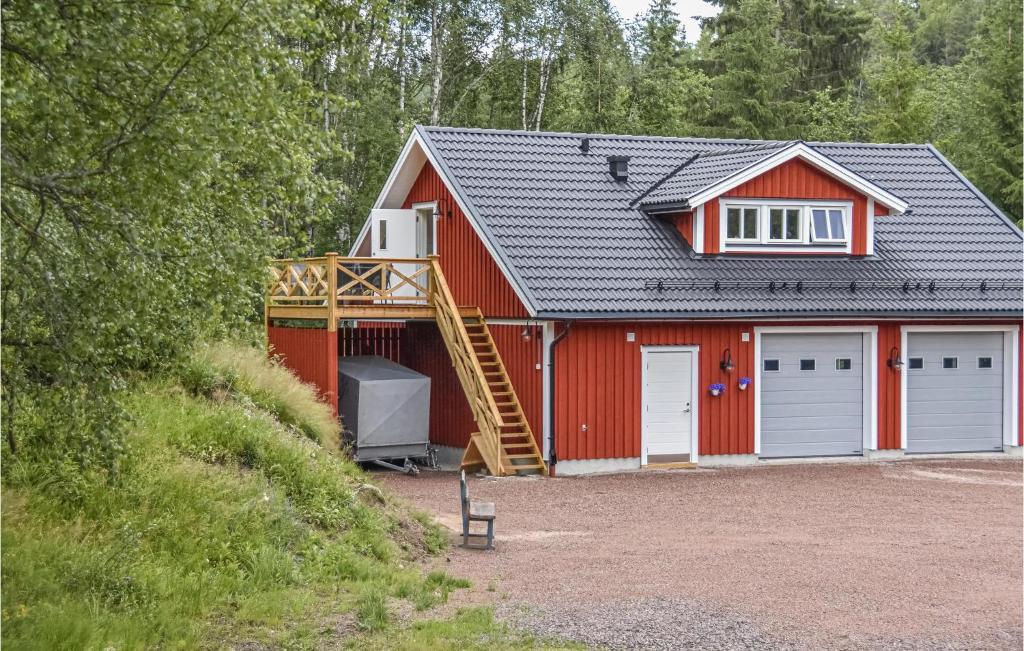 eine rote Scheune mit einer Treppe, die in die Garage führt in der Unterkunft 2 Bedroom Gorgeous Apartment In rjng in Årjäng