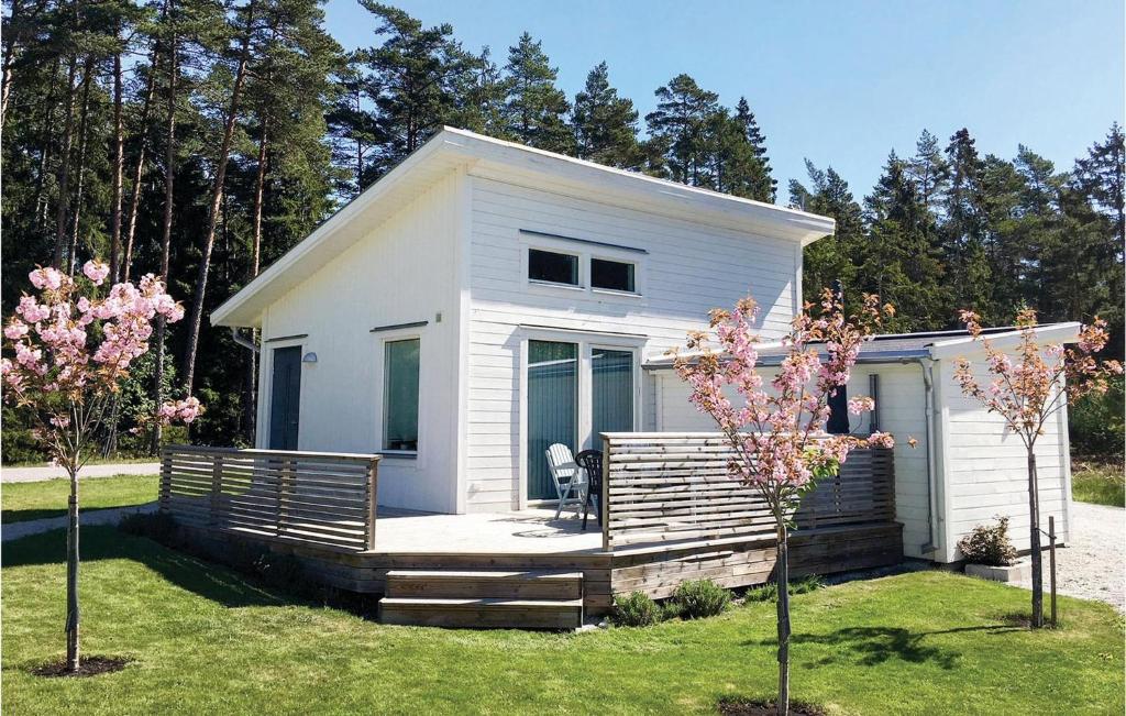 a small white house with a porch and two trees at Amazing Home In Gotlands Tofta With 2 Bedrooms in Västergarn