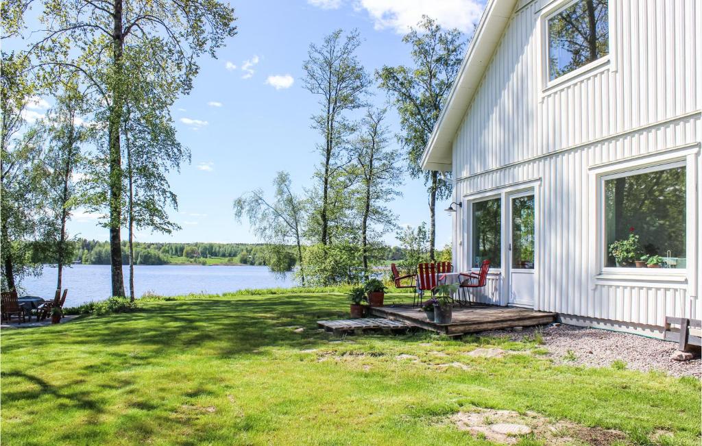 ein weißes Haus mit einer Terrasse und Seeblick in der Unterkunft 3 Bedroom Awesome Home In rebro in Örebro