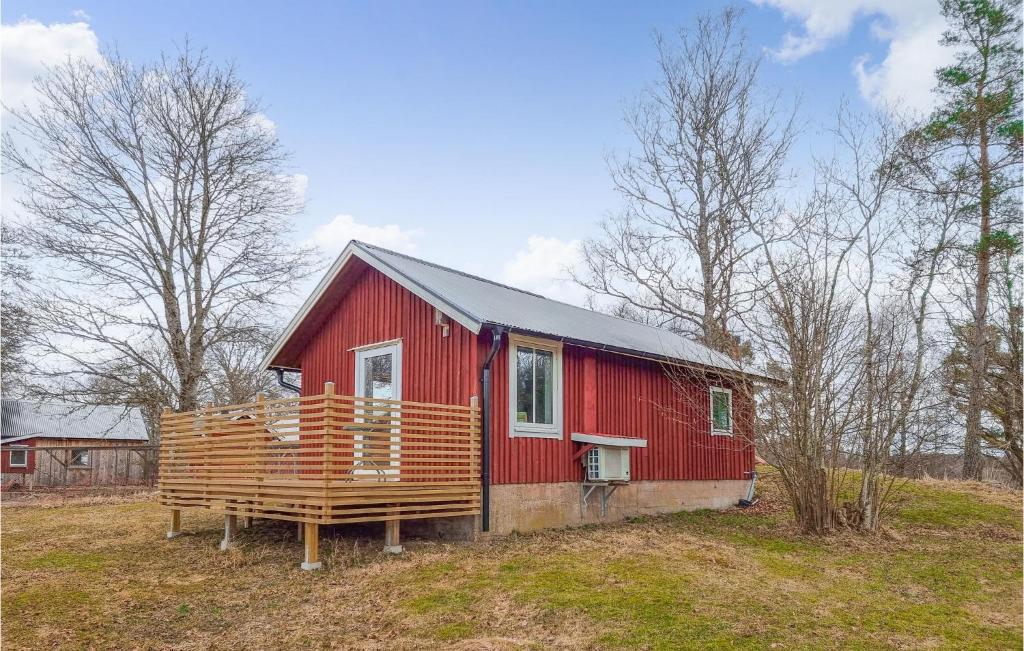 a red house with a deck in a field at Stunning Home In Sollebrunn With Kitchen in Sollebrunn