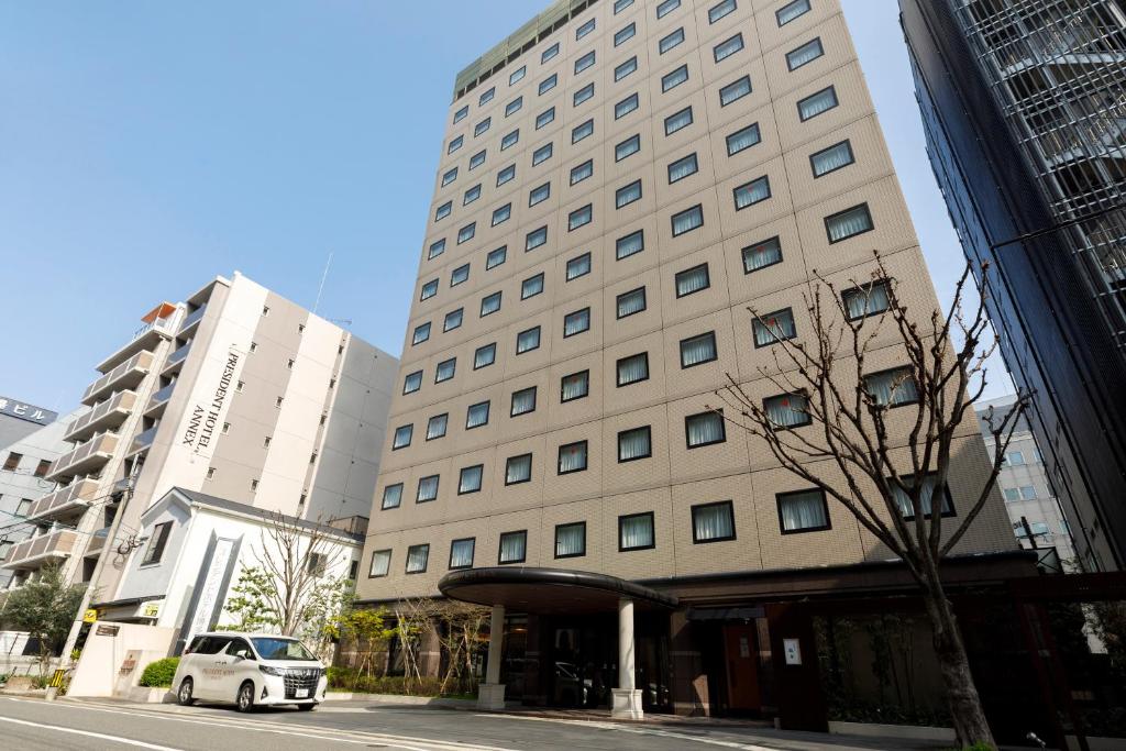 福岡市にあるプレジデントホテル博多の建物前に駐車した白車