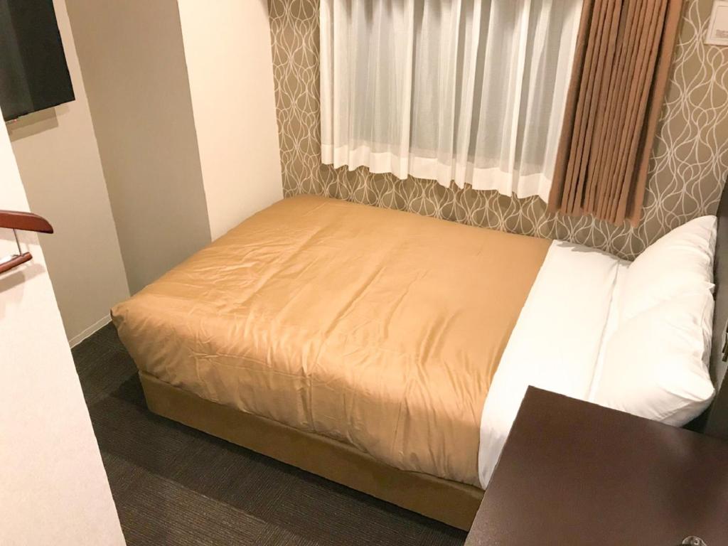 Postel nebo postele na pokoji v ubytování HOTEL LiVEMAX Shinyokohama