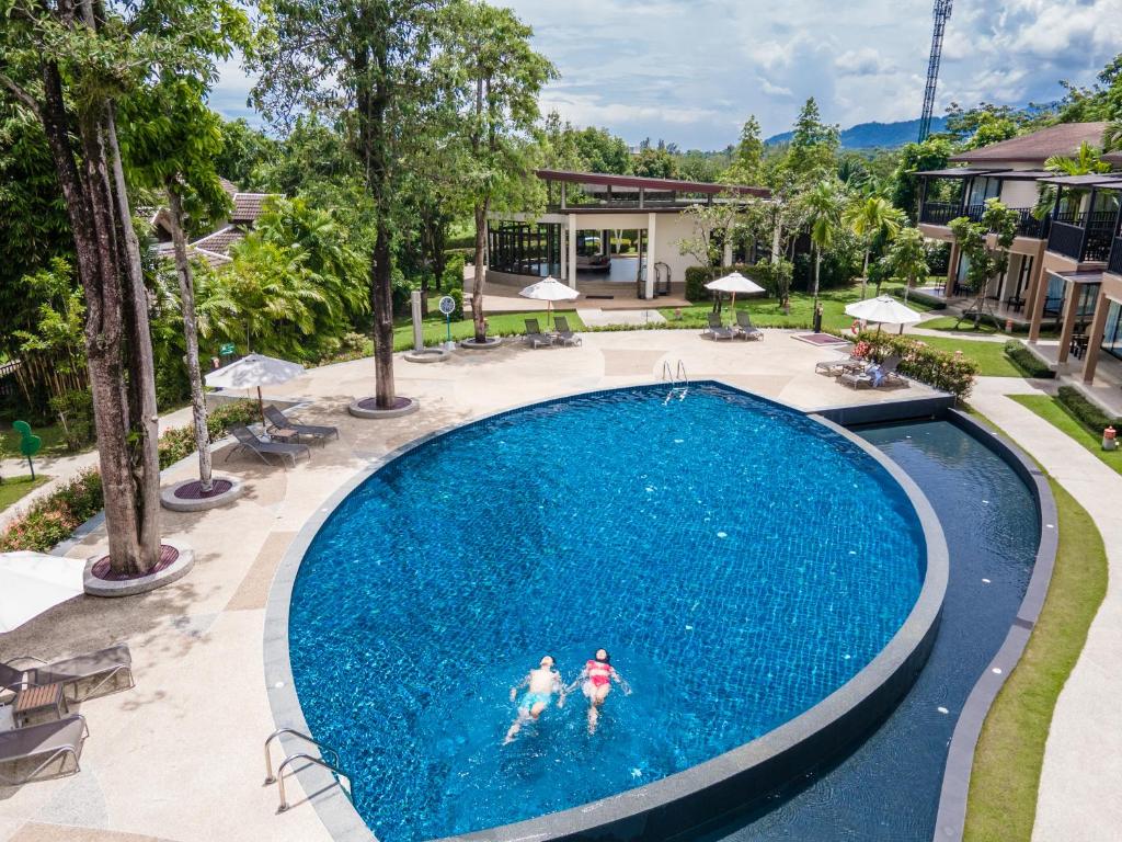 dos personas en una piscina en un complejo en The Leaf on The Sands by Katathani - SHA Extra Plus, en Khao Lak