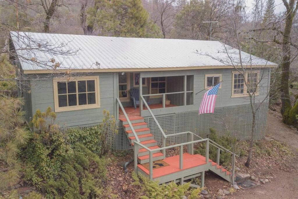 Una piccola casa con una bandiera americana sopra. di Baltyr Cabin a Miramonte