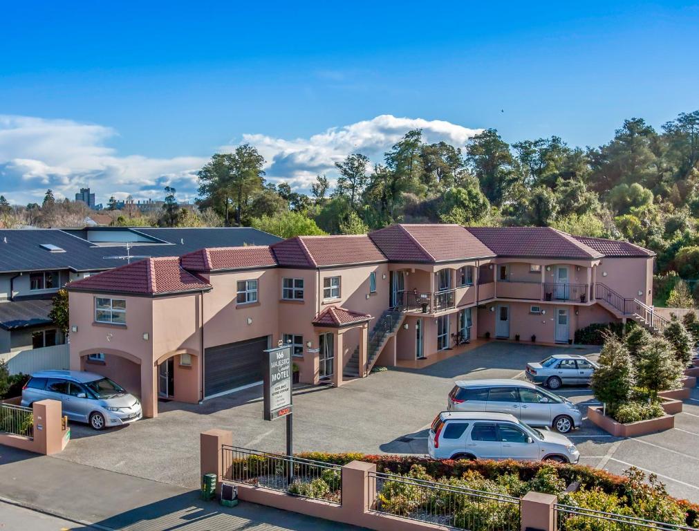 a group of houses with cars parked in a parking lot at 166 Majestic Court Motel in Christchurch