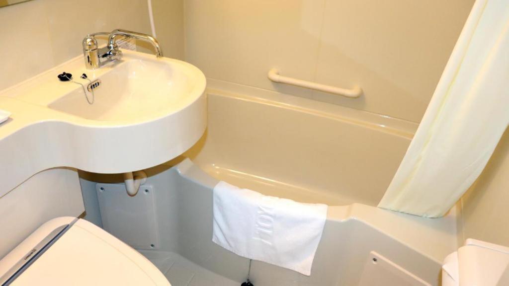 a bathroom with a sink and a toilet and a tub at Toyoko Inn Chubu International Airport No1 in Tokoname