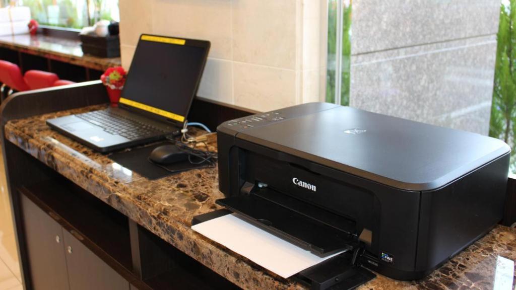 a black printer and a laptop on a counter at Toyoko Inn Chubu International Airport No1 in Tokoname