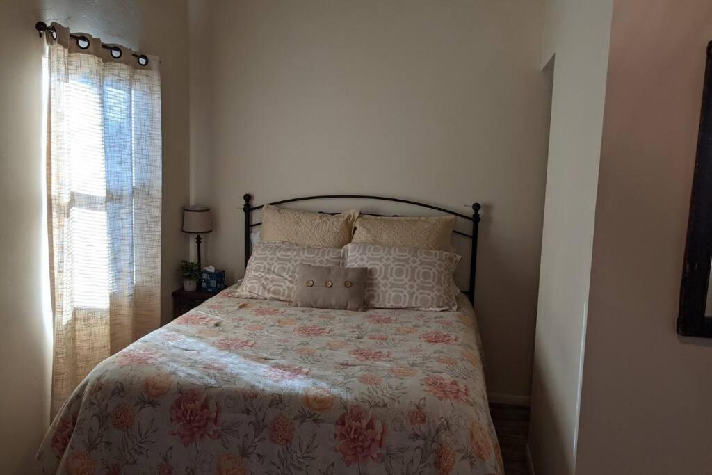 a bedroom with a bed with a floral bedspread and a window at Cozy Cabin in Squaw Valley