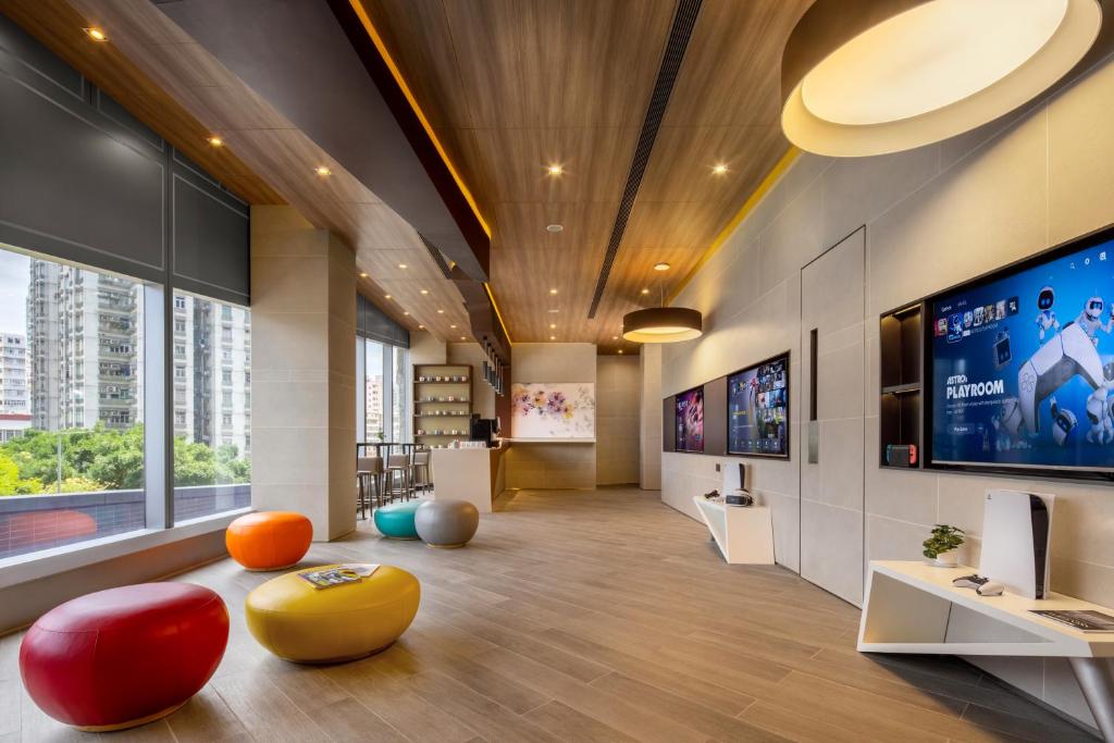 an office lobby with a large tv and colorful ottoman at Starphire Hotel in Hong Kong