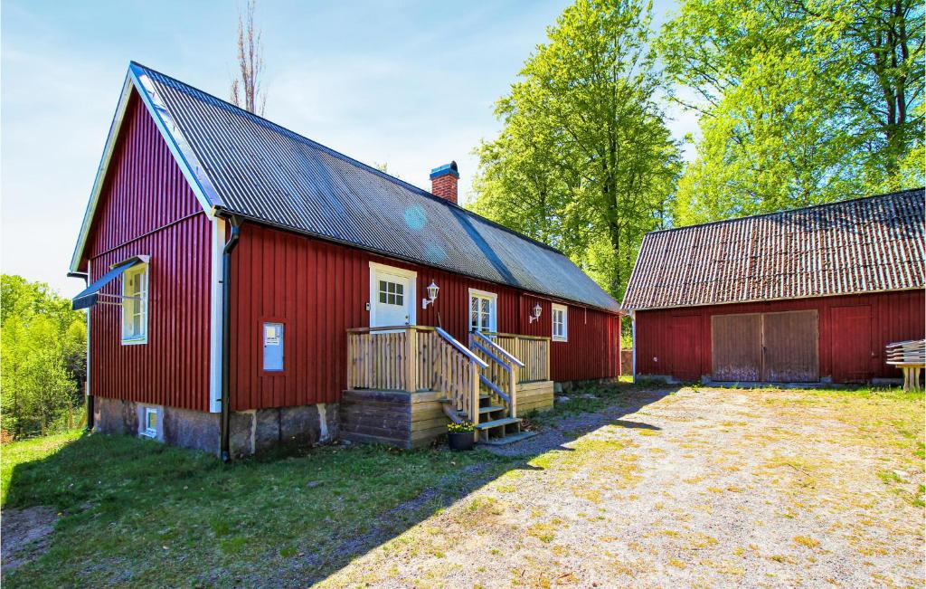 two red barns with a yard in front of it at Gorgeous Home In Munka Ljungby With Kitchen 