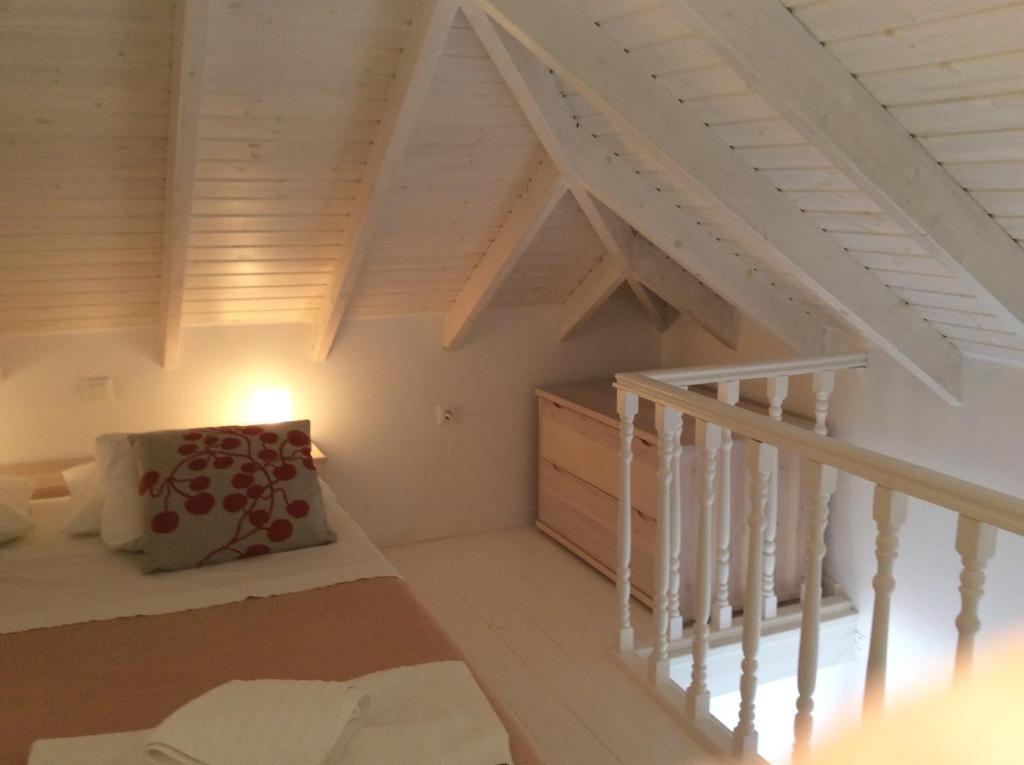 a attic room with a staircase and a bed at Amalia Harbor in Halki
