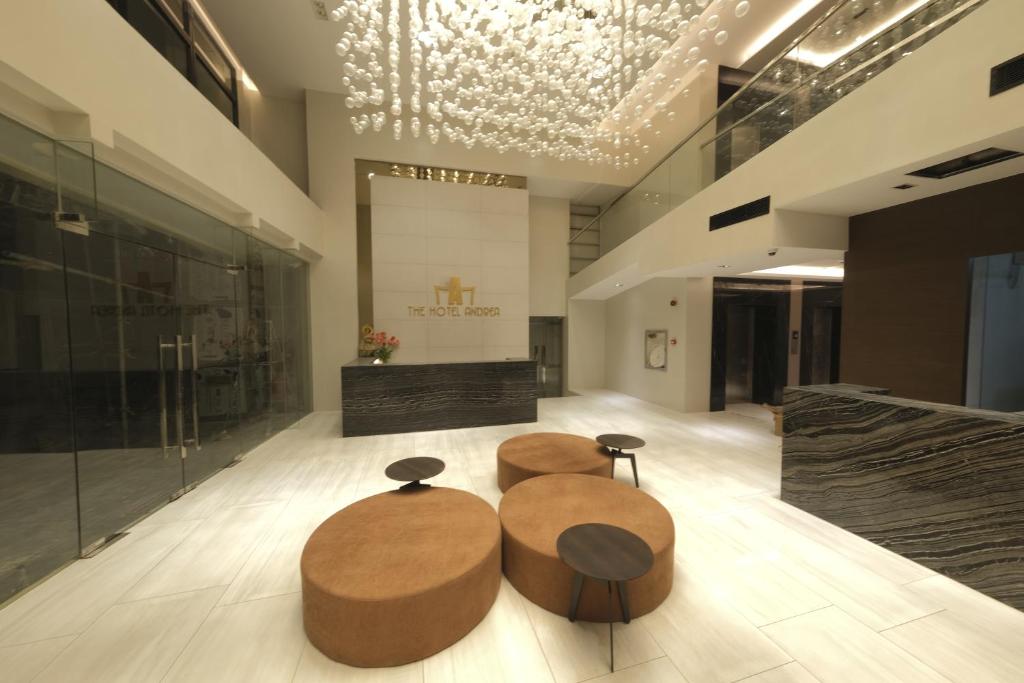 un vestíbulo con tres mesas circulares en un edificio en The Hotel Andrea, en Ciudad de Cauayán