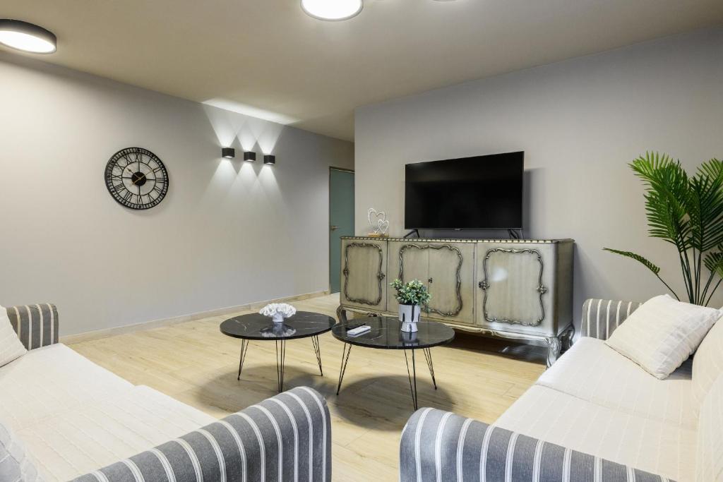 a living room with a couch and a tv on a wall at Louloudis Apartment in Limenas