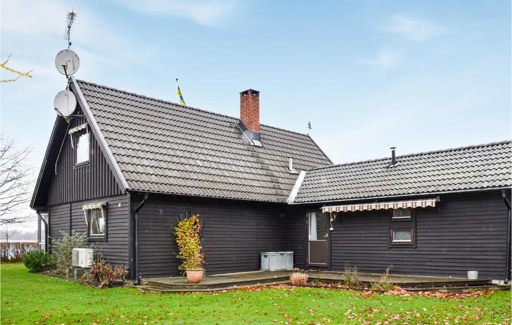 een zwart huis met een zwart dak bij Amazing Home In Ljungby With Lake View in Bolmsö
