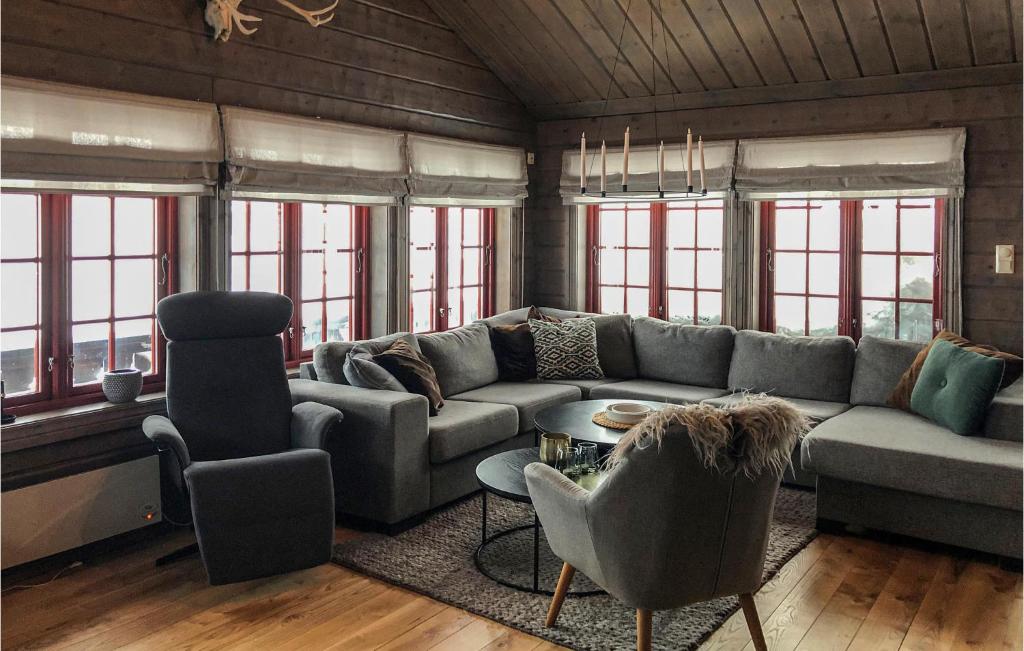 a living room with a couch and chairs and windows at Cozy Home In seral With House A Mountain View in Åseral