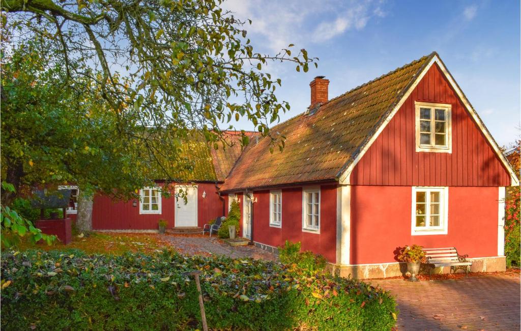 a red house with a bench in front of it at Stunning Home In Ystad With Sauna, 3 Bedrooms And Wifi in Ystad
