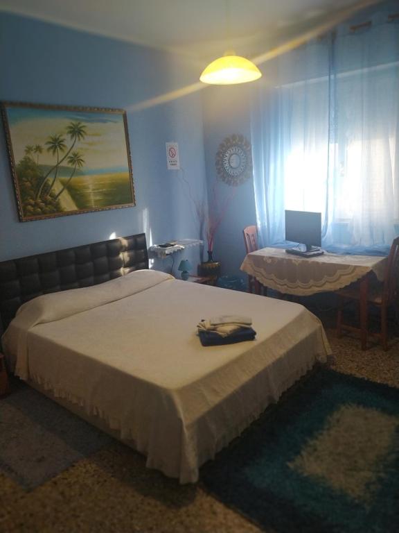 1 dormitorio con cama y mesa con ordenador portátil en Al Relax, en Cagliari