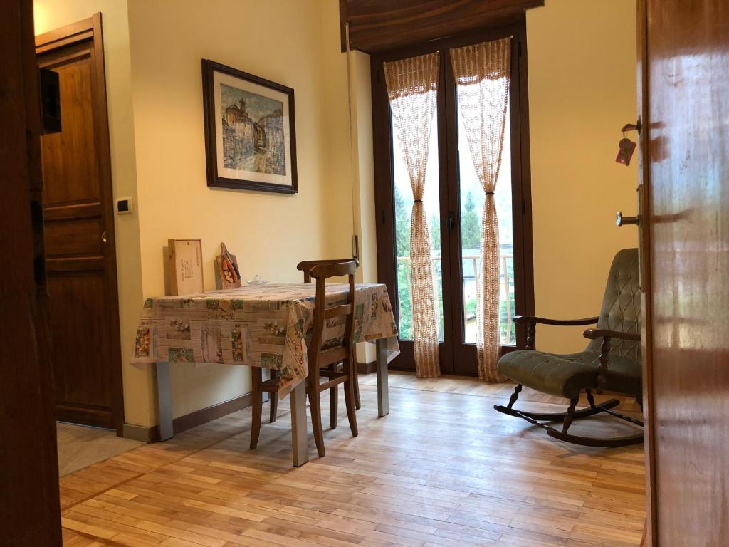comedor con mesa, sillas y ventanas en Borgo Villa, en Acceglio
