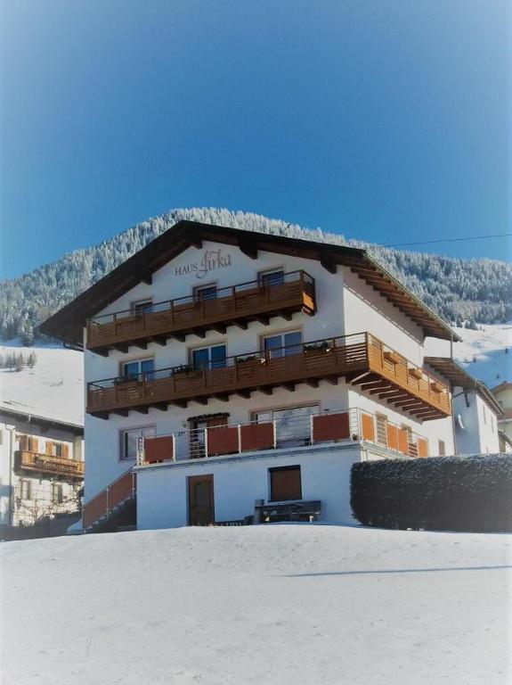 a building in the snow in front of a mountain at Haus Jirka in Nauders