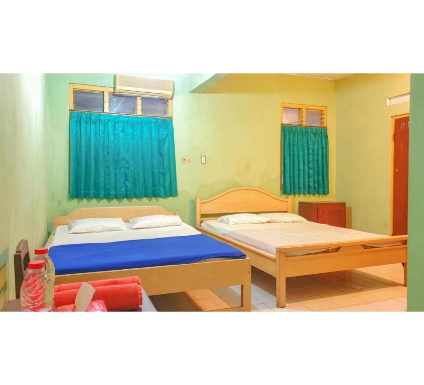 Postel nebo postele na pokoji v ubytování Hotel Jaya Kusuma near Candi Prambanan Mitra RedDoorz