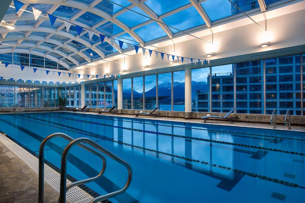 einen Pool mit Blick auf ein Gebäude in der Unterkunft Auberge Vancouver Hotel in Vancouver