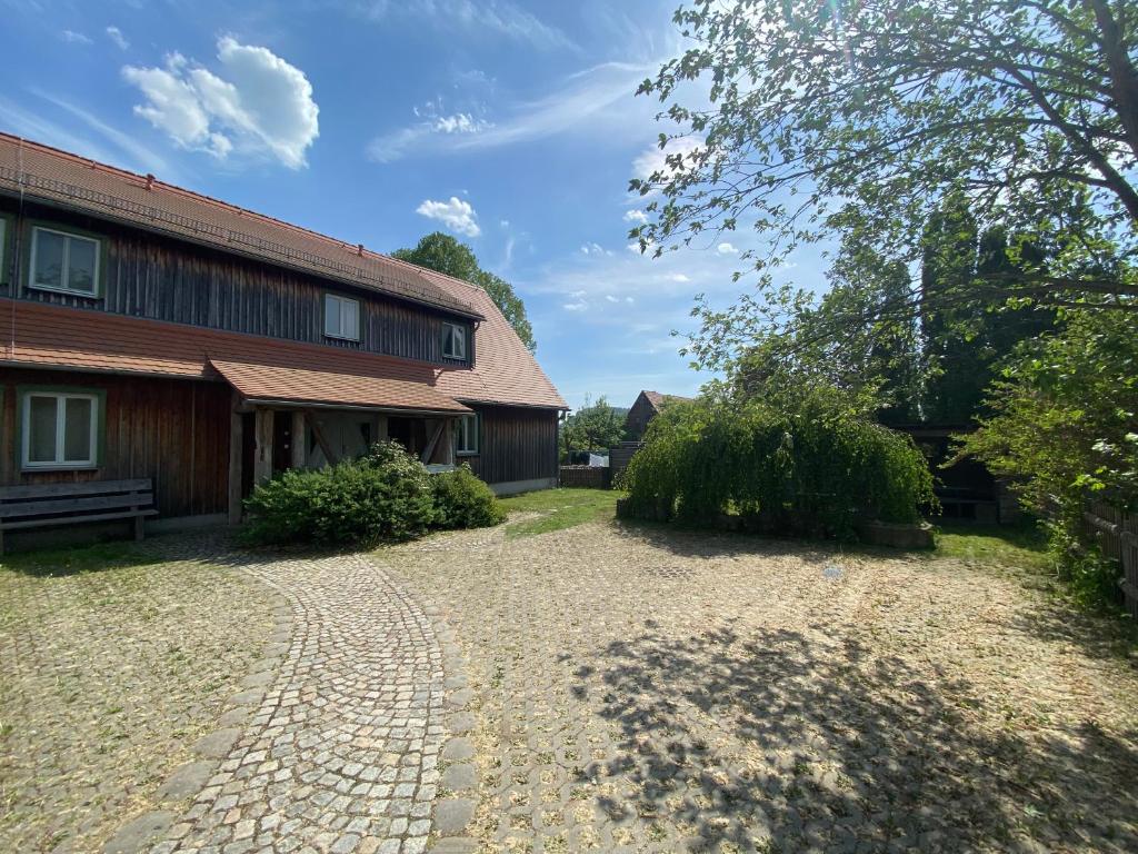a house with a brick driveway next to a building at Haus Gamrigblick in Waltersdorf