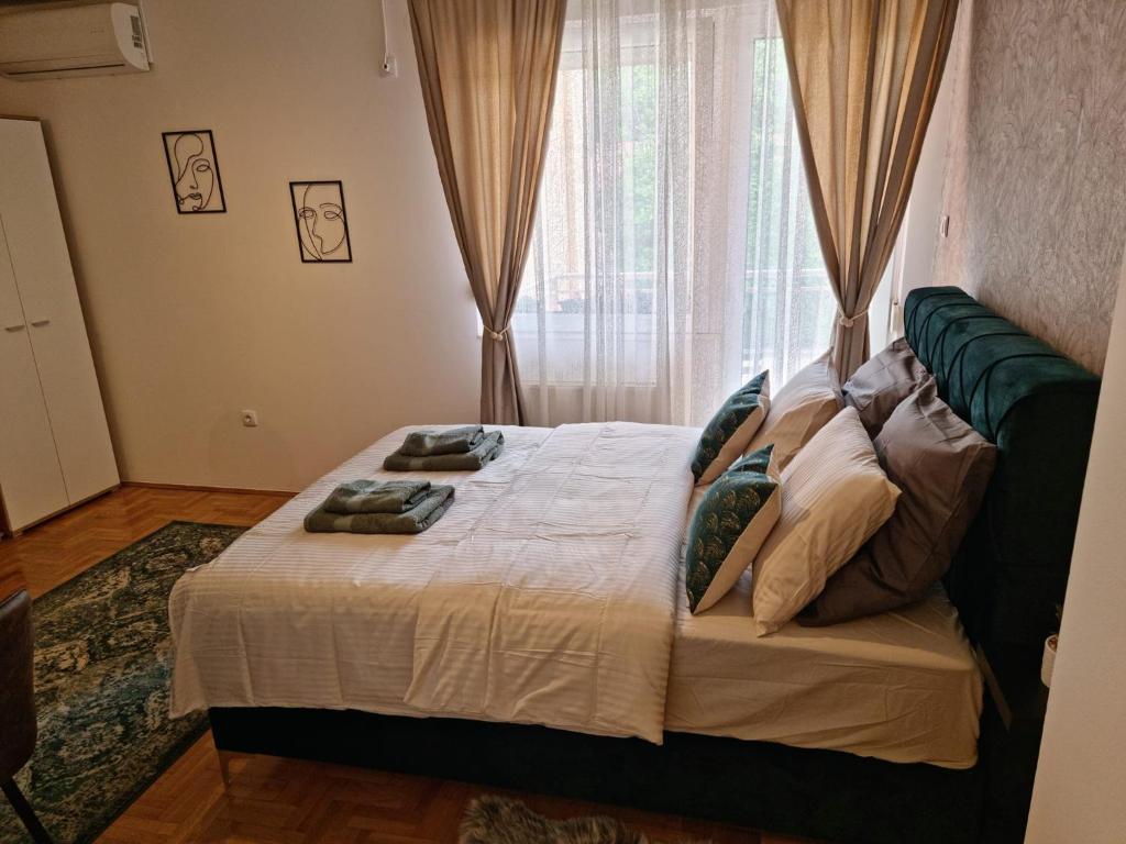 1 dormitorio con cama con almohadas y ventana en Monte Home Center, en Novi Sad