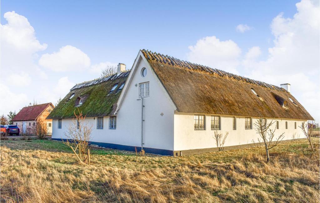 a white house with a grass roof on a field at Stunning Home In Staffanstorp With Kitchen in Staffanstorp