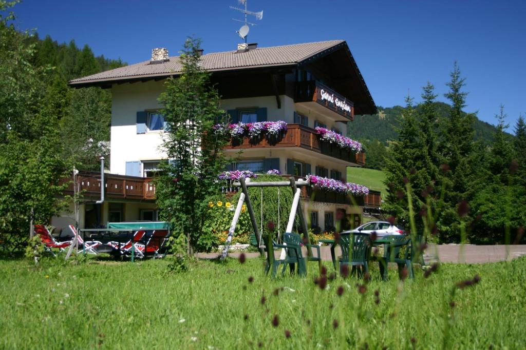 a house with a swing in front of it at Pension Enzian in Badia